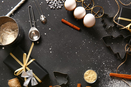 Frame made of different tools and ingredients for Christmas gingerbread cookies on black background