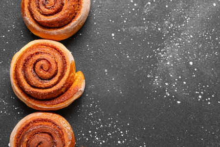 Tasty cinnamon rolls on black backgroundの写真素材