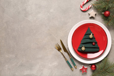 Beautiful table setting with candy cane, fir branches and Christmas balls on gray backgroundの写真素材