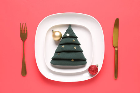 Beautiful table setting with Christmas balls on red backgroundの写真素材