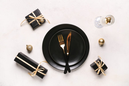 Beautiful table setting with Christmas balls and gift boxes on white background