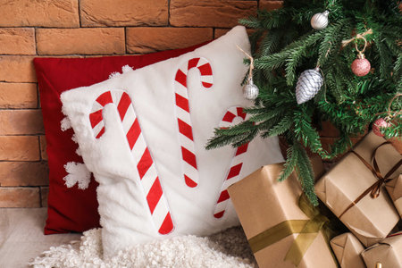 Stylish cushions and gift boxes under Christmas tree, closeupの写真素材