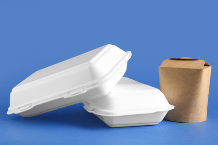 Takeaway paper containers and cutlery on blue backgroundの写真素材