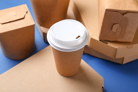 Takeaway paper cup and different boxes on blue background, closeupの写真素材