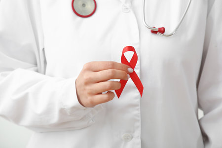 Young female doctor with red ribbon, closeup. World AIDS day conceptの写真素材