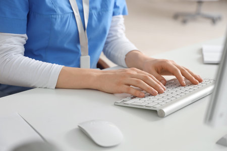 Female doctor working with computer at table in clinic, closeupの写真素材
