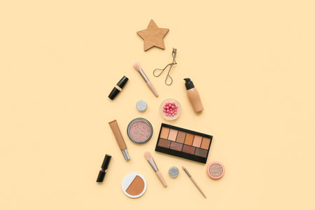 Different decorative cosmetics and Christmas decoration on yellow backgroundの写真素材