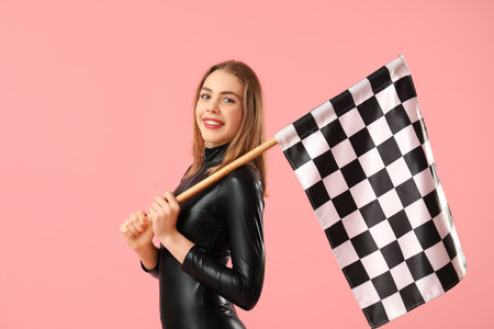 Happy young woman with racing flag on pink backgroundの写真素材