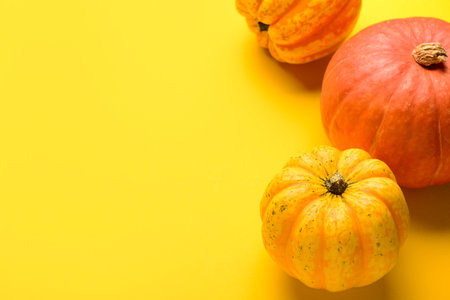 Fresh pumpkins on yellow backgroundの写真素材