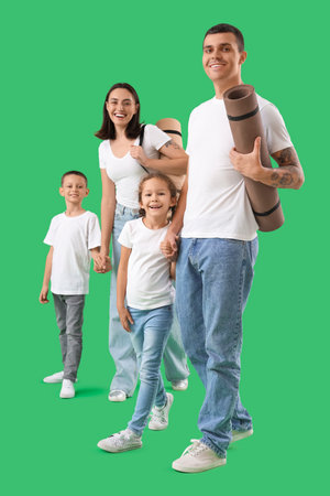Happy family with fitness mats on green backgroundの写真素材