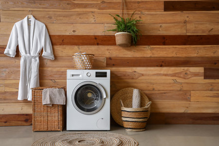 Laundry room interior with washing machine, wicker basket and bathrobeの写真素材