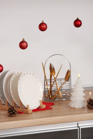 Holder with dishes on counter and Christmas balls in kitchen, closeupの写真素材