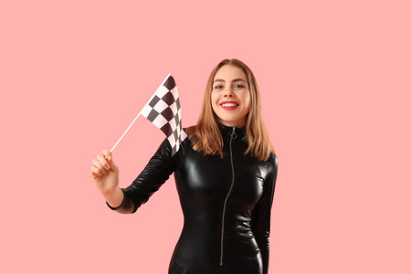Happy young woman with racing flag on pink backgroundの写真素材
