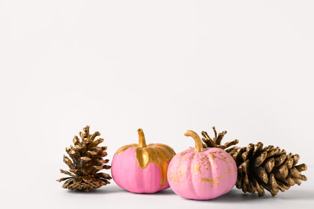 Pink painted pumpkins and golden cones on white backgroundの写真素材