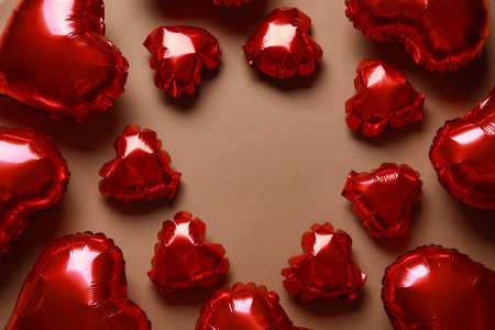 Frame made of red heart shaped air balloons on brown backgroundの写真素材