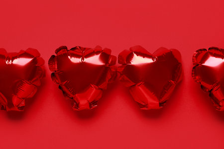 Heart shaped air balloons on red backgroundの写真素材