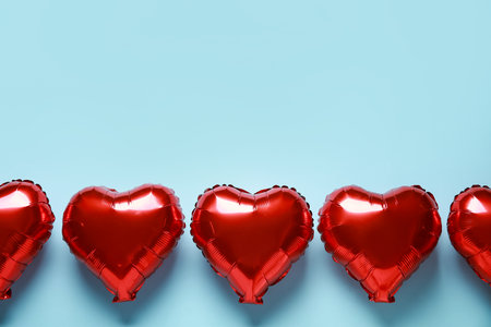 Red heart shaped air balloons on blue backgroundの写真素材