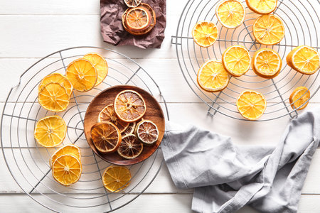 Stands and plate with dried orange slices on white wooden backgroundの写真素材