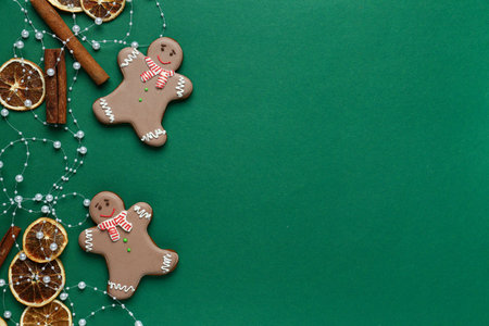 Gingerbread cookies with dry orange slices and cinnamon on green backgroundの写真素材
