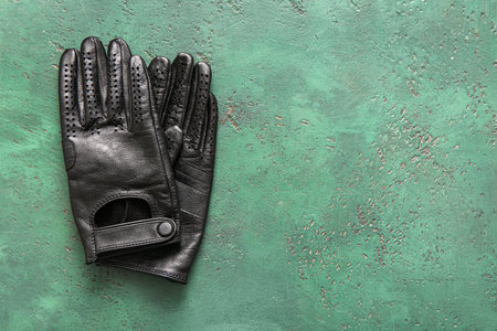 Pair of female leather gloves on green backgroundの写真素材