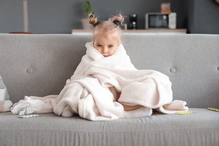 Sick little girl with plaid at homeの写真素材