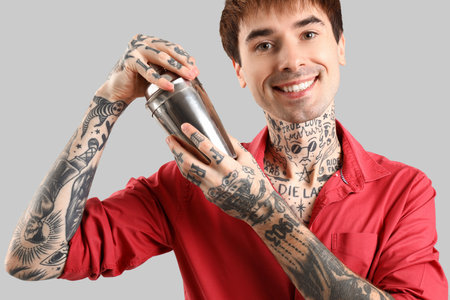 Young male bartender with shaker on white backgroundの写真素材