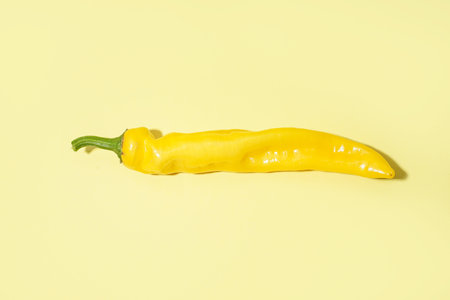 Yellow chili pepper on color backgroundの写真素材