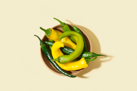 Wooden bowl with fresh chili peppers on white backgroundの写真素材