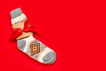 Christmas knitted socks on red backgroundの写真素材