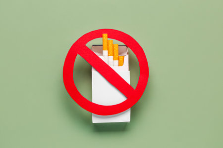 Box of cigarettes with STOP sign on green background. Lung cancer conceptの写真素材