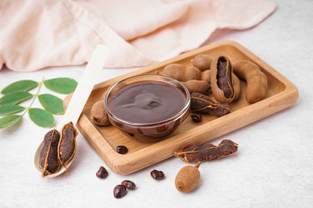 Bowl with tasty tamarind jam and fruits on white backgroundの写真素材