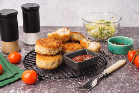 Grid of tasty meat cutlets with sauce on gray backgroundの写真素材
