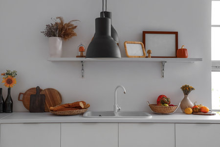 Kitchen counter with sink, pumpkins, apples and blank framesの写真素材
