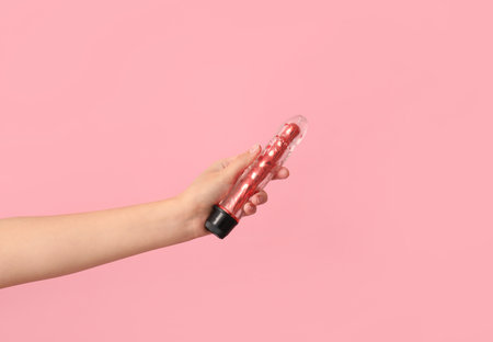 female hand with vibrator on pink backgroundの写真素材