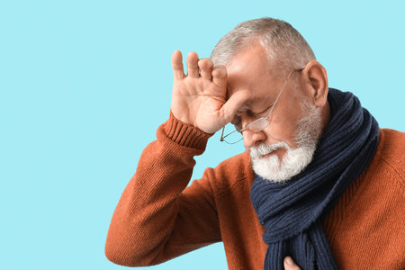 Sick mature man on blue background, closeupの写真素材