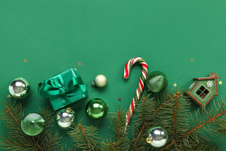 Christmas balls with fir branches, candy cane and gift box on green backgroundの写真素材