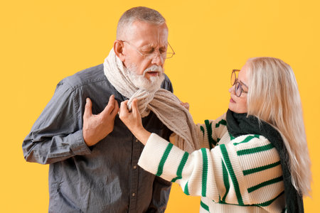Sick mature couple on yellow backgroundの写真素材