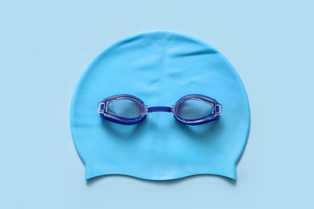 Swimming cap and goggles on color backgroundの写真素材