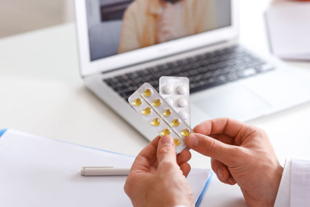 Young doctor prescribing pills to patient online in office, closeupの写真素材