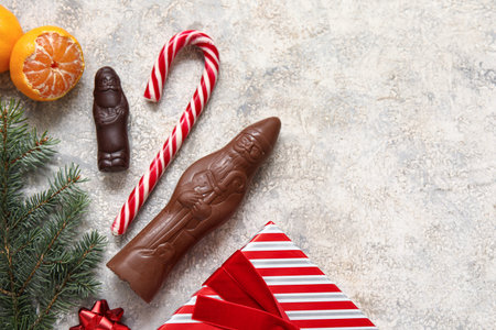 Composition with chocolate Santa Clauses, candy cane and tangerines on grunge backgroundの写真素材