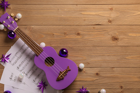 Composition with ukulele, music, sheets and Christmas decorations on wooden backgroundの写真素材