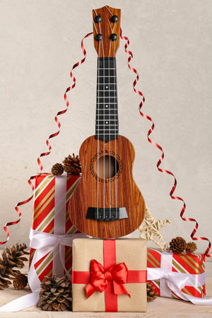 Composition with ukulele, Christmas gifts and decorations on light wooden tableの写真素材