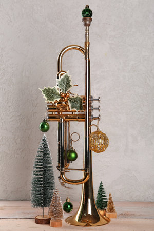 Composition with golden trumpet and Christmas decorations on light wooden tableの写真素材