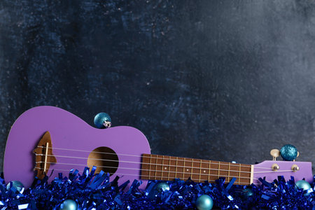 Composition with ukulele and Christmas decorations on dark color backgroundの写真素材