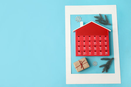 Composition with paper picture frame, winter advent calendar and Christmas decor on color backgroundの写真素材