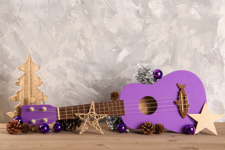 Composition with ukulele and beautiful Christmas decorations on wooden table against grunge backgroundの写真素材