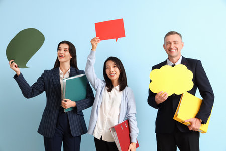 Business people holding speech bubbles on blue backgroundの写真素材