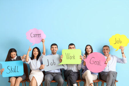 Business people holding speech bubbles with words on blue backgroundの写真素材