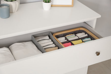 Open chest of drawers full of clothes at home, closeupの写真素材