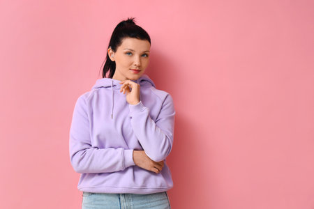 Young woman with hearing aid on pink backgroundの写真素材
